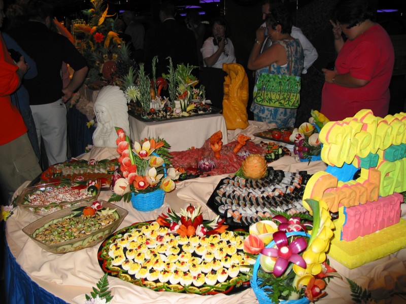 The white guy on the left is a block of butter carved into an indian. The right orange thing, the block of cheese in a fish's form. The middle: an eagle made of meat!